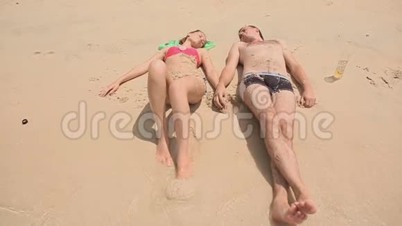 年轻夫妇躺在海滩上视频的预览图