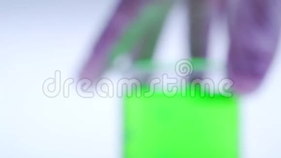科学家一只无菌手套里的手放着一个绿色的化学瓶视频的预览图