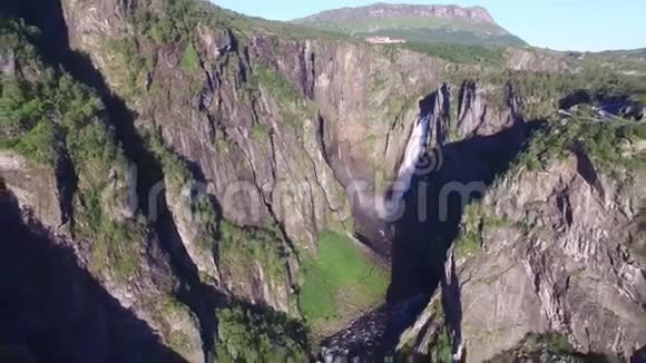 野生自然岩石山瀑布松树森林悬崖晴天景观在惊人的4k空中无人机视野视频的预览图