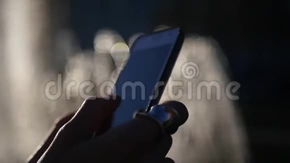一个女孩手指上戴着一枚漂亮的戒指手里拿着一部手机用一个漂亮的屏幕点击视频的预览图