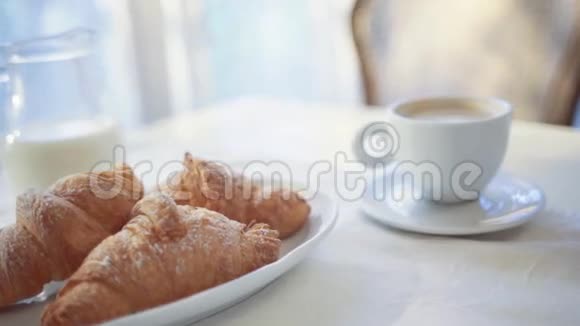 桌上摆放着牛奶脆角面包和热咖啡早晨的例行公事完美的早餐法语视频的预览图