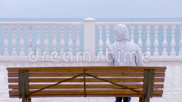 穿着白色夹克和引擎盖的女人在美丽的露台上海景在海滨后景视频的预览图