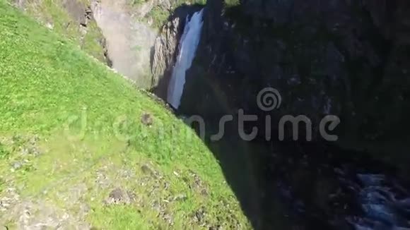 阳光明媚的一天4k无人驾驶飞机在野生自然石岩山瀑布悬崖山上俯瞰松树视频的预览图