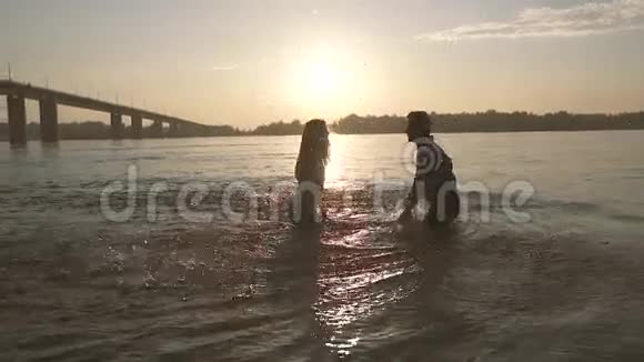 一对嬉戏的夫妇在河里喷水视频的预览图