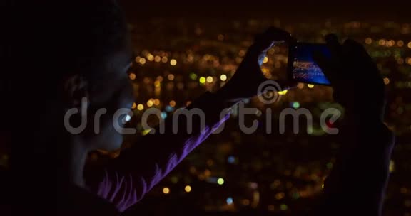女商人用手机拍城市照片视频的预览图