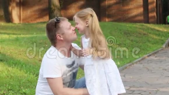快乐的父亲和他的小女儿在夏天阳光明媚的公园擦鼻子视频的预览图