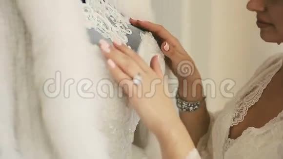 新娘抚摸她的白色连衣裙视频的预览图