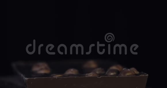 黑巧克力块与坚果细节缓慢特写宏观倾斜巧克力棒的透视图视频的预览图
