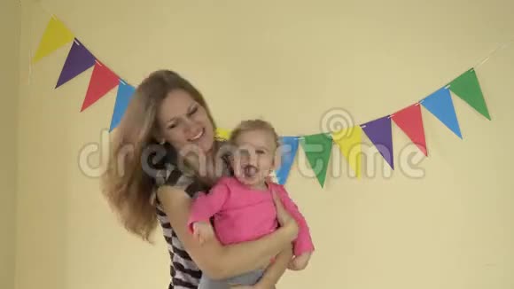 1岁的女婴在黄色背景下和妈妈跳舞视频的预览图