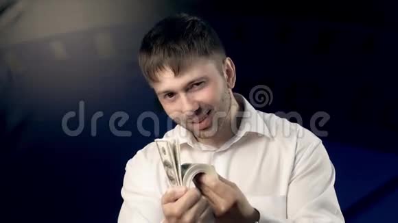 一个人站在蓝色的背景下看着他的大量钱视频的预览图