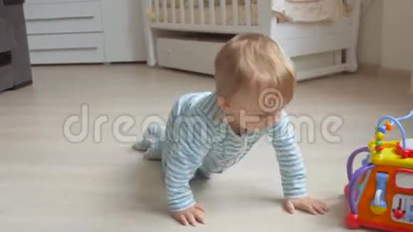 可爱的男婴在客厅地板上爬行拿着一个玩具视频的预览图