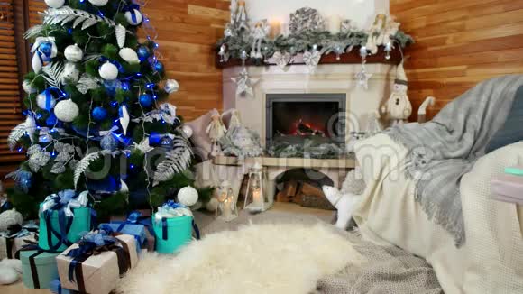 女孩把礼物放在圣诞树下孩子正在为父母准备新年惊喜平安夜视频的预览图