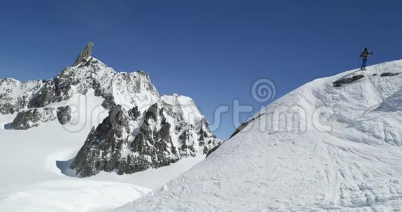 在阳光明媚的日子里人们在雪山山脊上自由滑雪登山滑雪活动滑雪者冬季雪地运动视频的预览图