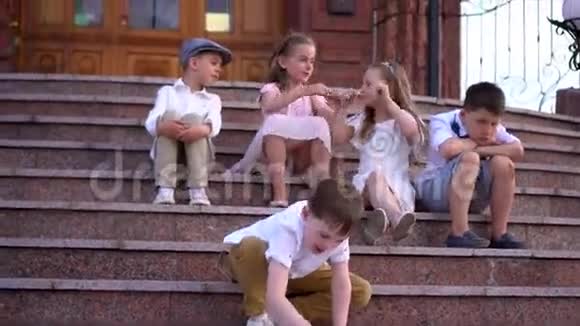 一群穿着复古衣服的小孩子坐在老砖楼的梯子上视频的预览图