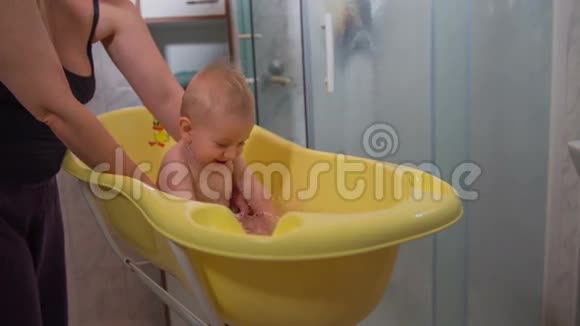 在黄色塑料浴缸里快乐的小孩视频的预览图
