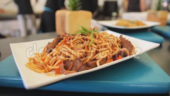 在桌子上的盘子里煮熟的意大利面条特写放大摄像机传统食物带肉的面条视频的预览图