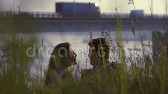 年轻夫妇在高大的草地上放松时浪漫地接吻视频的预览图