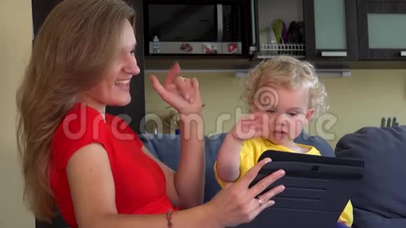 女人和小女孩挥手看平板电脑视频的预览图