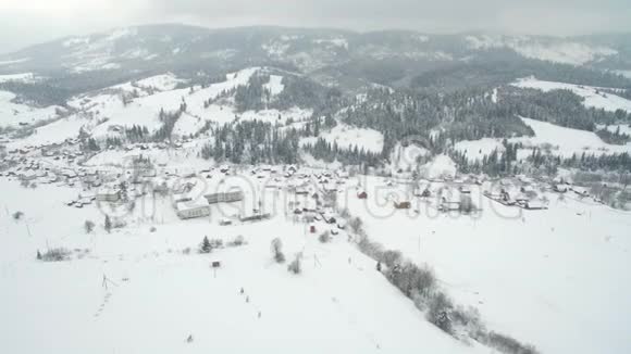 在山上飞过城市乌克兰喀尔巴阡山脉冬季冰雪覆盖的小镇视频的预览图