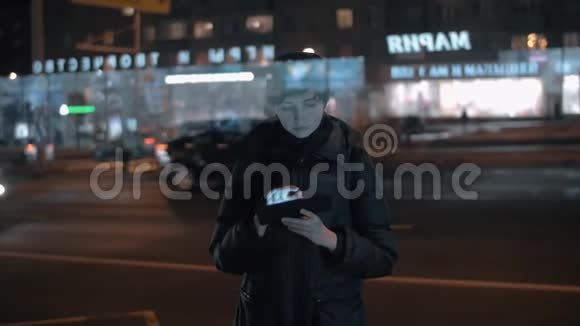 在繁忙的夜晚城市里使用数码平板电脑的年轻女子视频的预览图