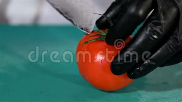 厨师用烹饪刀把红熟番茄切成两半视频的预览图