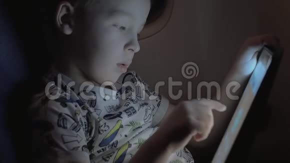 男孩乘飞机旅行玩平板电脑游戏视频的预览图