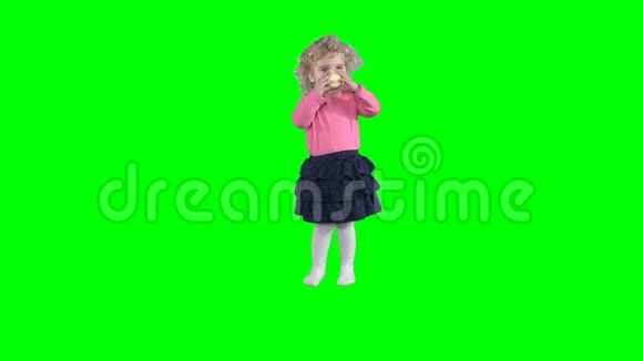 可爱的小女孩从绿色背景的塑料杯中喝茶视频的预览图
