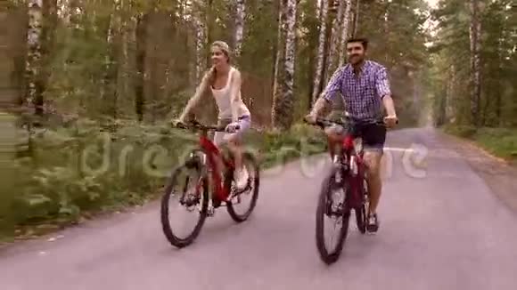 年轻的女人和英俊的男人一起快乐地骑车视频的预览图