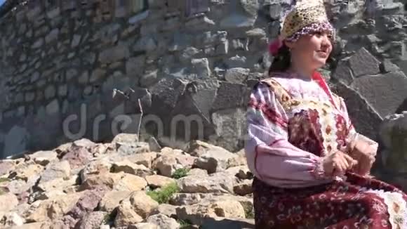 坐在岩石上的女孩俄罗斯民族服装视频的预览图