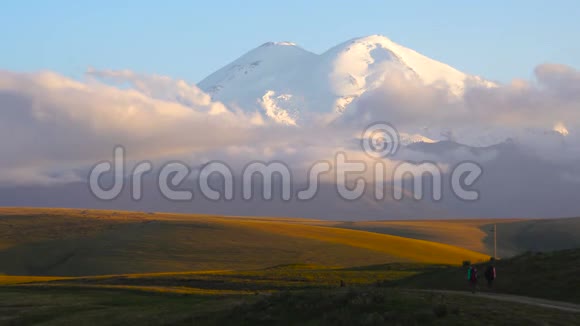 两个人正徒步前往高加索山脉公路旁的埃尔布鲁斯山朋友们要在云彩里登上埃布鲁斯视频的预览图