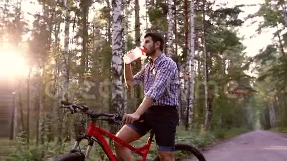 年轻骑自行车的人坐在自行车上喝水视频的预览图
