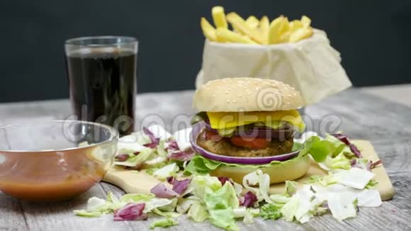 在黑色背景的木桌上放4k多利汉堡薯条可乐和番茄酱视频的预览图