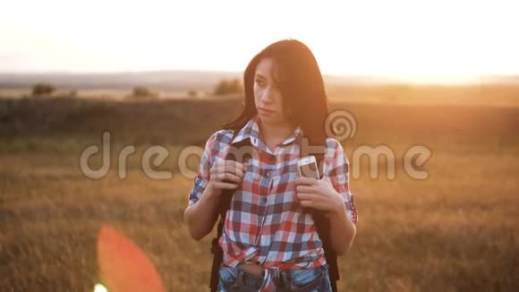 嬉皮青年女孩步行与背包智能手机享受日落在高峰后方背景视图下的游客视频的预览图