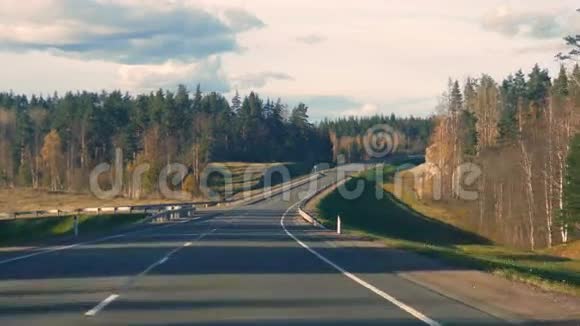 从一辆移动的汽车看到树林间的道路视频的预览图