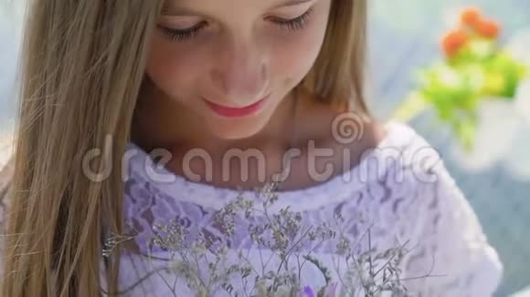 幸福的小美丽模特的肖像手里拿着花欣赏慢慢地视频的预览图
