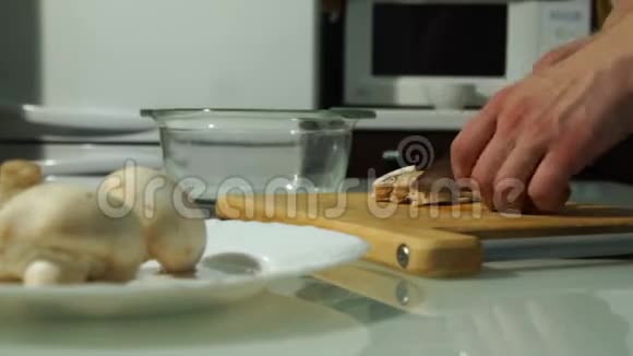 男厨师用木板切鲜蘑菇视频的预览图