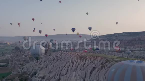 许多五颜六色的热气球飞在山上卡帕多西亚日出时的全景视频的预览图