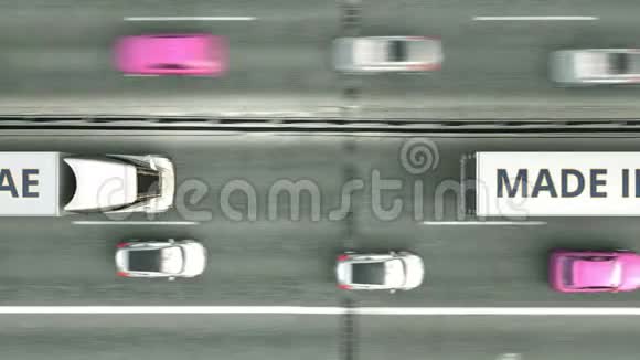空中俯视拖车卡车与MADE在阿联酋文本驾驶沿公路阿拉伯联合酋长国的业务视频的预览图