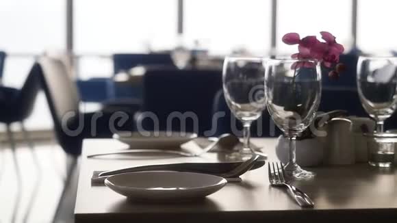 大厅有装饰的桌子餐厅里有餐具大窗户旁有鲜花用来庆祝婚礼视频的预览图