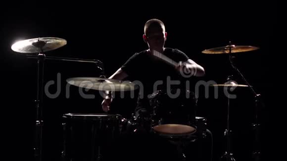 音乐家用棍子在鼓上演奏专业的好音乐黑色背景剪影慢动作视频的预览图