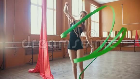 韵律体操年轻女子用丝带训练体操动作缓慢视频的预览图