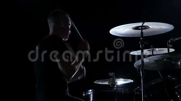 音乐家用棍子在鼓上演奏专业的好音乐黑色背景剪影慢动作视频的预览图
