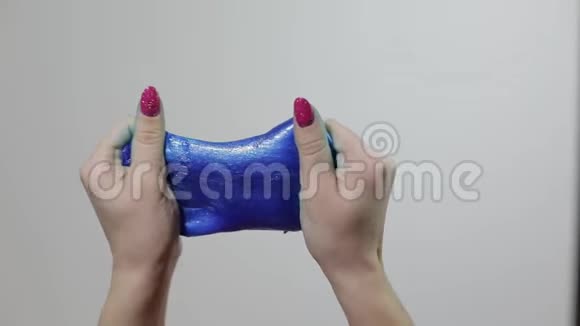 女人的手玩着奇怪的令人满意的蓝色黏液粘性物质抗压力视频的预览图
