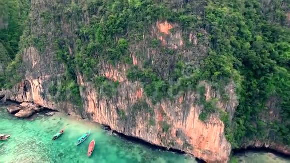小旅游船在平静的蓝绿色海水中周围环绕着4k大热带石质山林视频的预览图