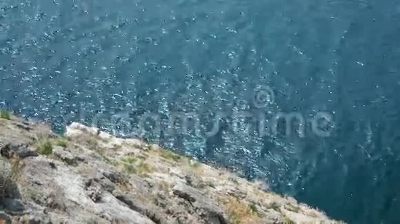巨大的岩石下平静的大海视频的预览图