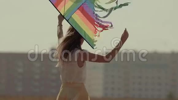 美丽的皮肤白皙的年轻女子拿着风筝旋转着视频的预览图