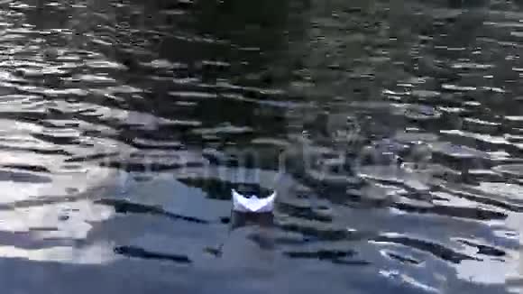 小折纸船浮在涟漪的河水上后续行动视频的预览图