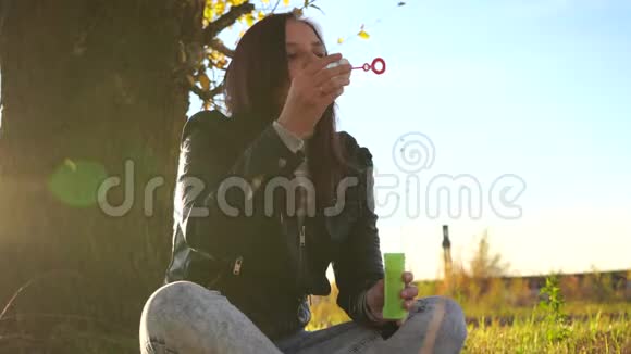 女人在户外吹肥皂泡在公园里玩得开心的少女吹肥皂泡视频的预览图