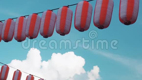 纸制的红白日本灯笼挂在蓝云天背景上视频的预览图