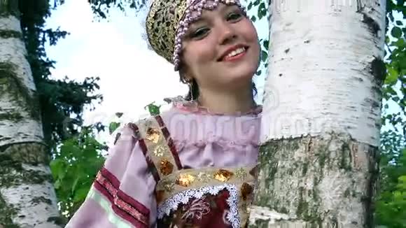 穿着民族服装的俄罗斯女孩用桦树做梦视频的预览图